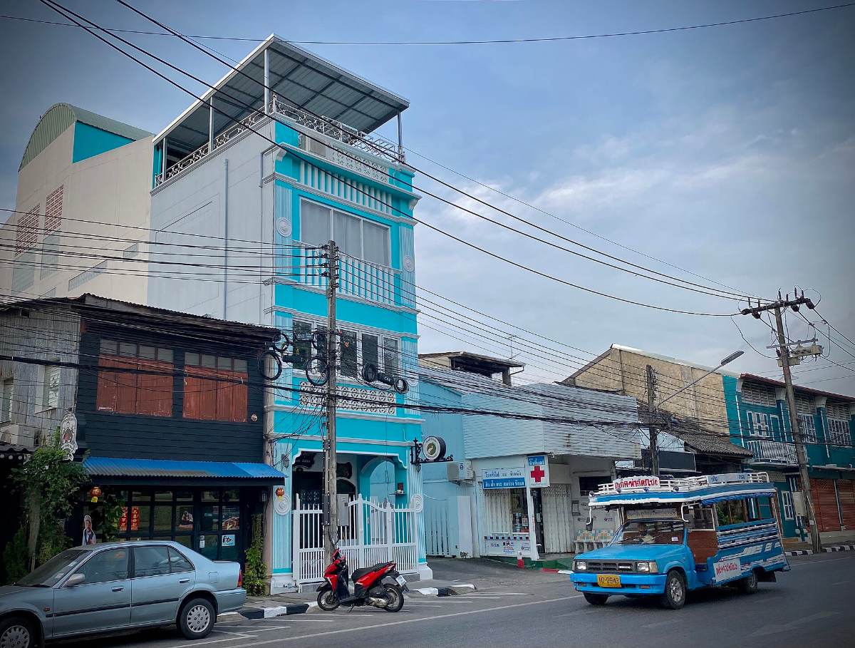 Blue songthaew local bus on a Phuket Town street of Sino-Portuguese shophouses — songthaew fares keep Thailand travel costs at 15 to 30 baht a ride
