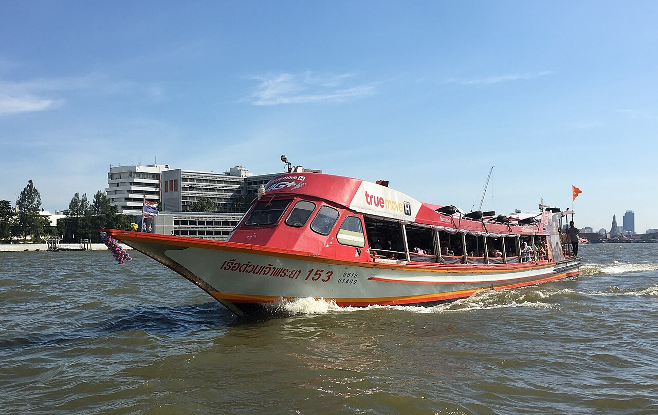 Orange flag Chao Phraya Express Boat on the river in Bangkok - the 20-baht Thailand budget travel route past the Grand Palace and Wat Arun