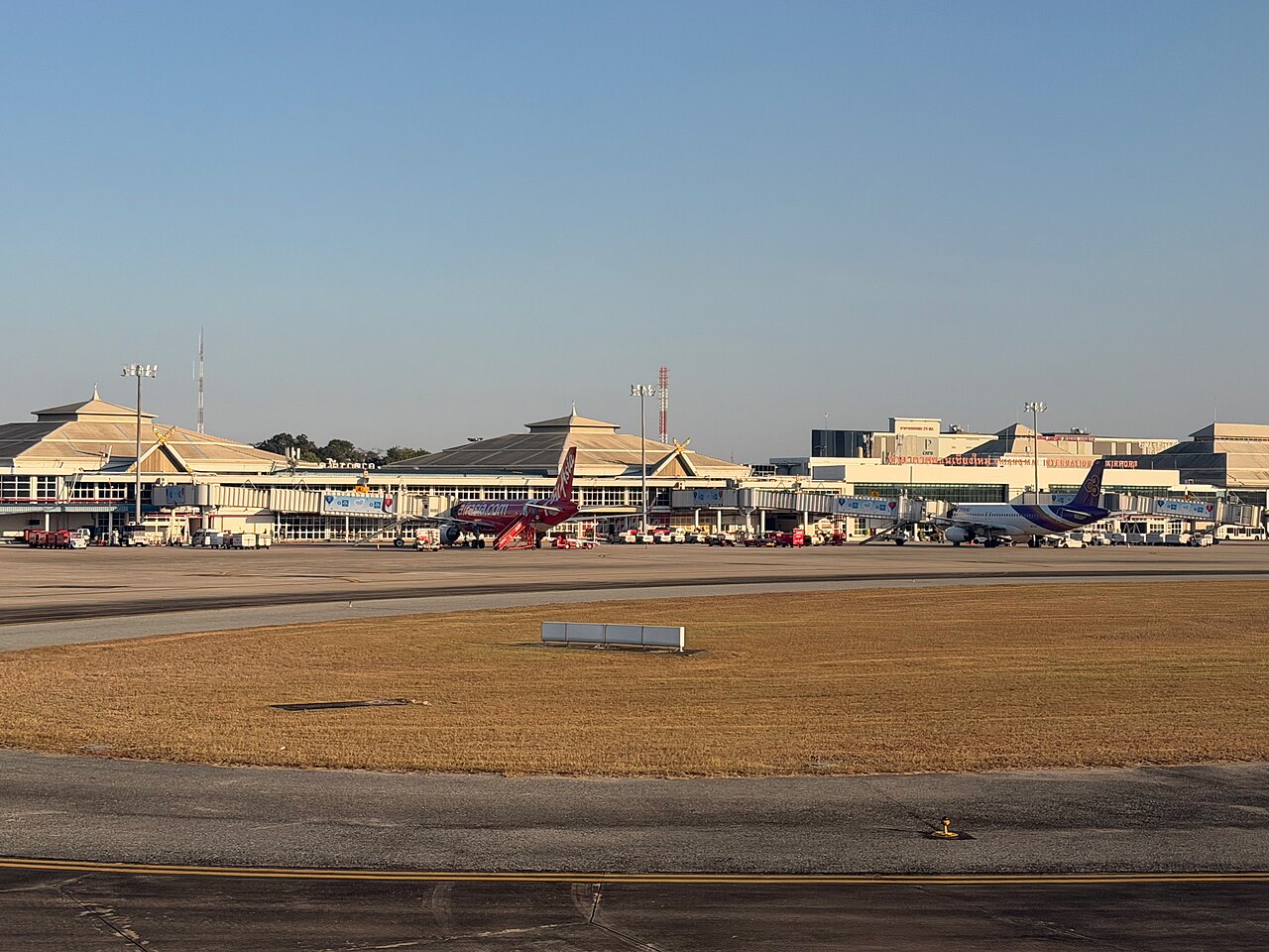 Chiang Mai International Airport terminal with AirAsia and Thai Airways jets at the gates, the arrival point where Thailand budget travel decisions start for visitors heading to the Old City