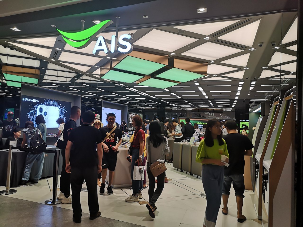 Busy AIS mobile network shop inside a Bangkok shopping mall, where a local SIM card Thailand visitors buy in the city costs the same as at the airport counter