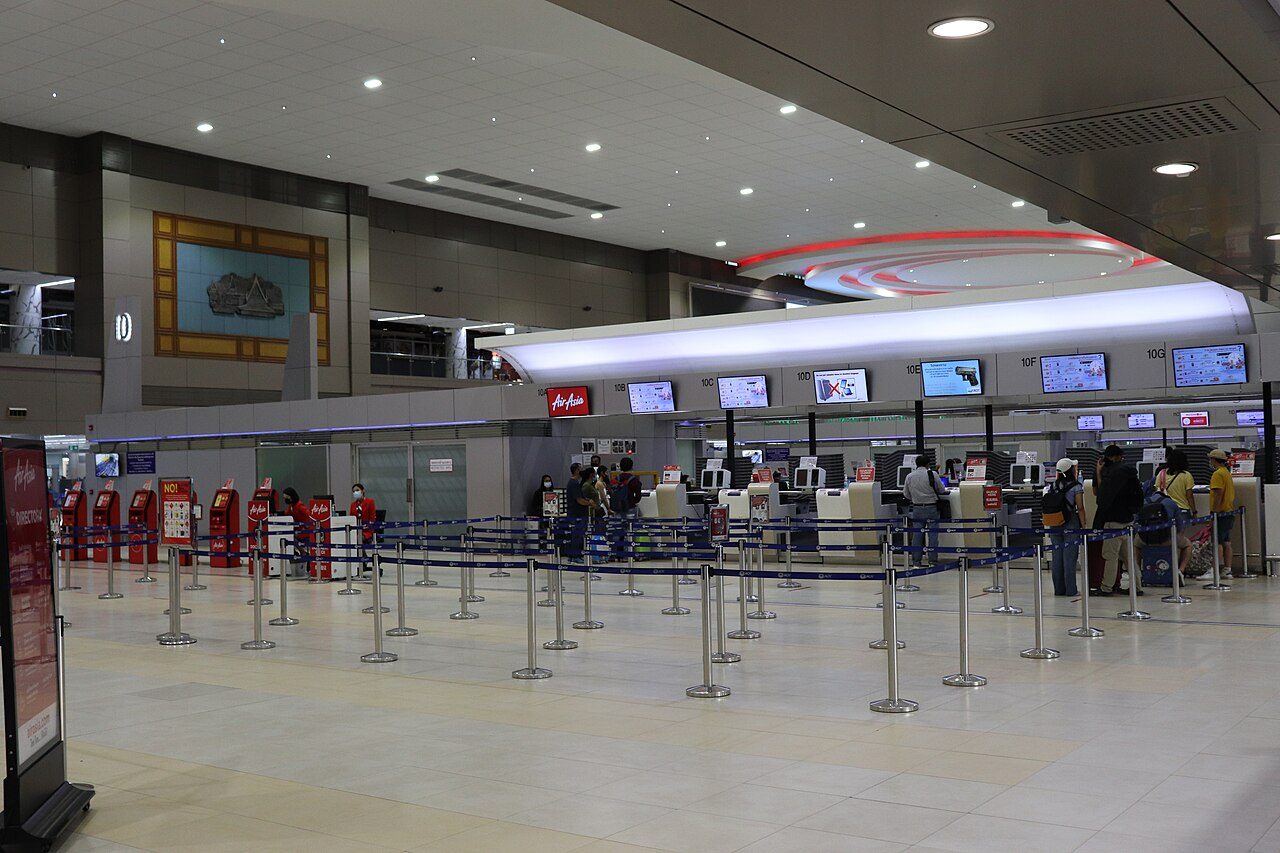 Thai AirAsia check-in counters and self-service kiosks at Don Mueang Airport Terminal 2 in Bangkok, where cheap travel Thailand domestic flight baggage fees are charged at the bag drop