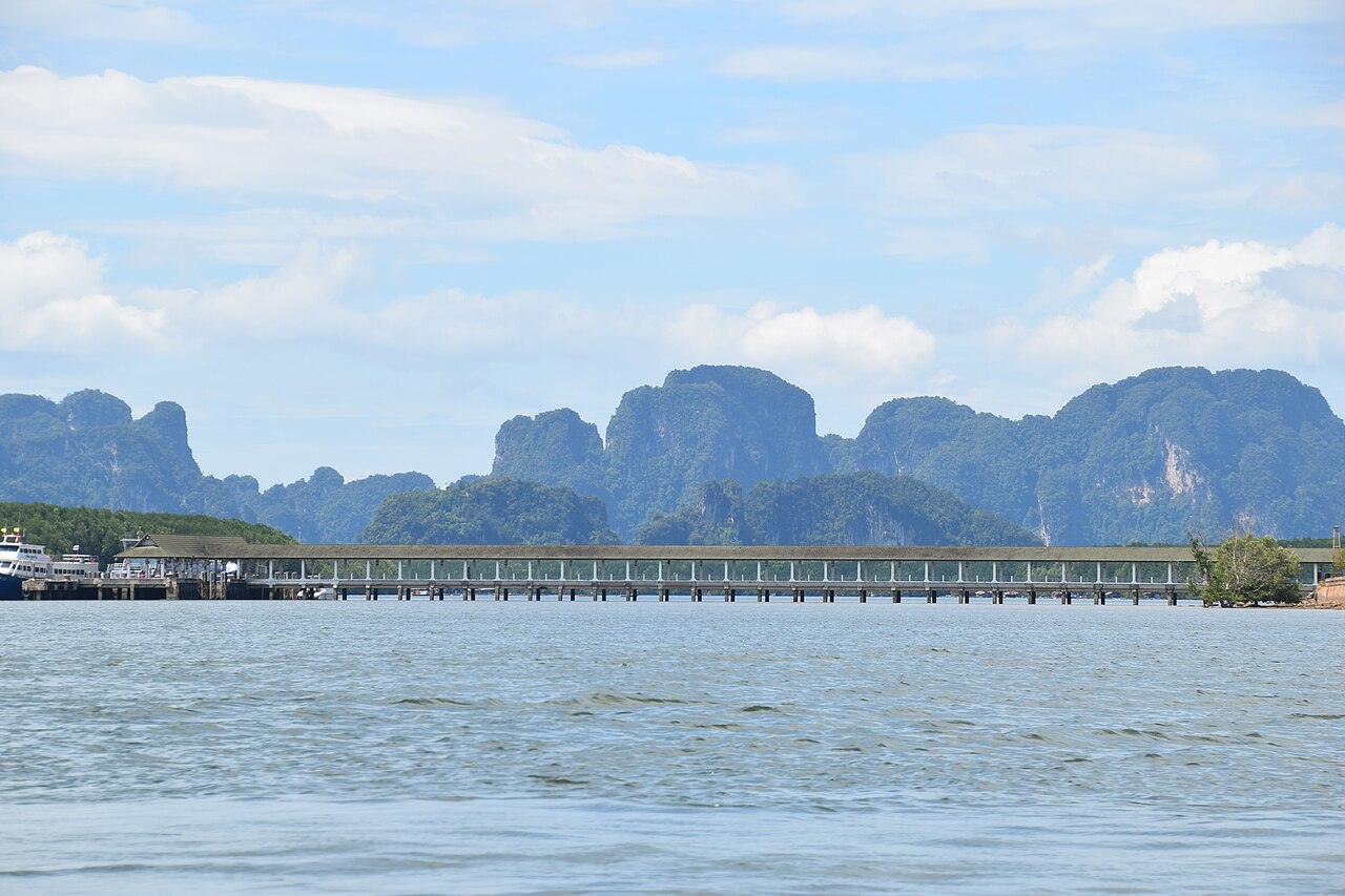 Klong Jilad Pier near Krabi Town with a passenger ferry moored at the jetty and limestone karsts behind, the cheapest departure point for Phi Phi in this Thailand budget travel guide