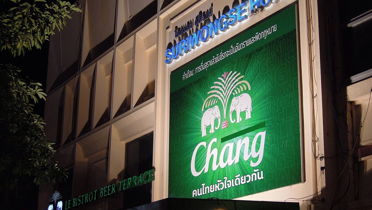 Large illuminated Chang beer sign above a hotel beer terrace in Chiang Mai, Thailand, where hotel venues are exempt from the alcohol sales hours that set Thailand travel costs for an evening drink