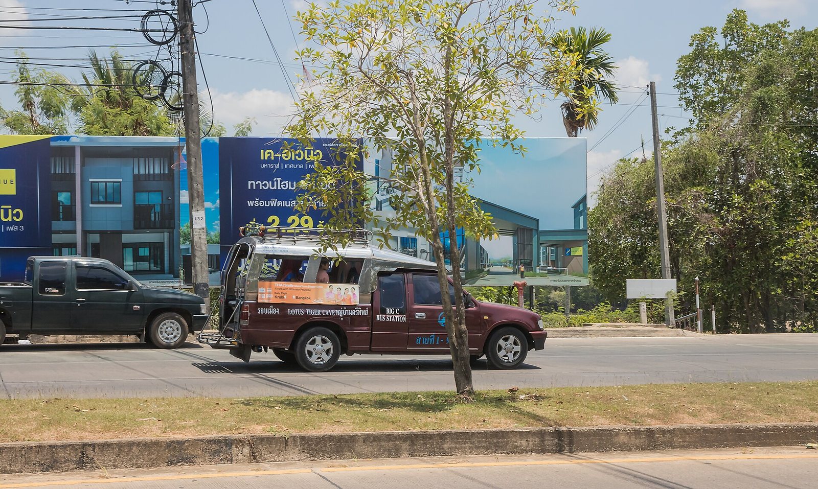 A shared songthaew pickup truck working a numbered route in Krabi, Thailand, with its destination board listing the bus station, the cheapest local transport in Krabi travel costs
