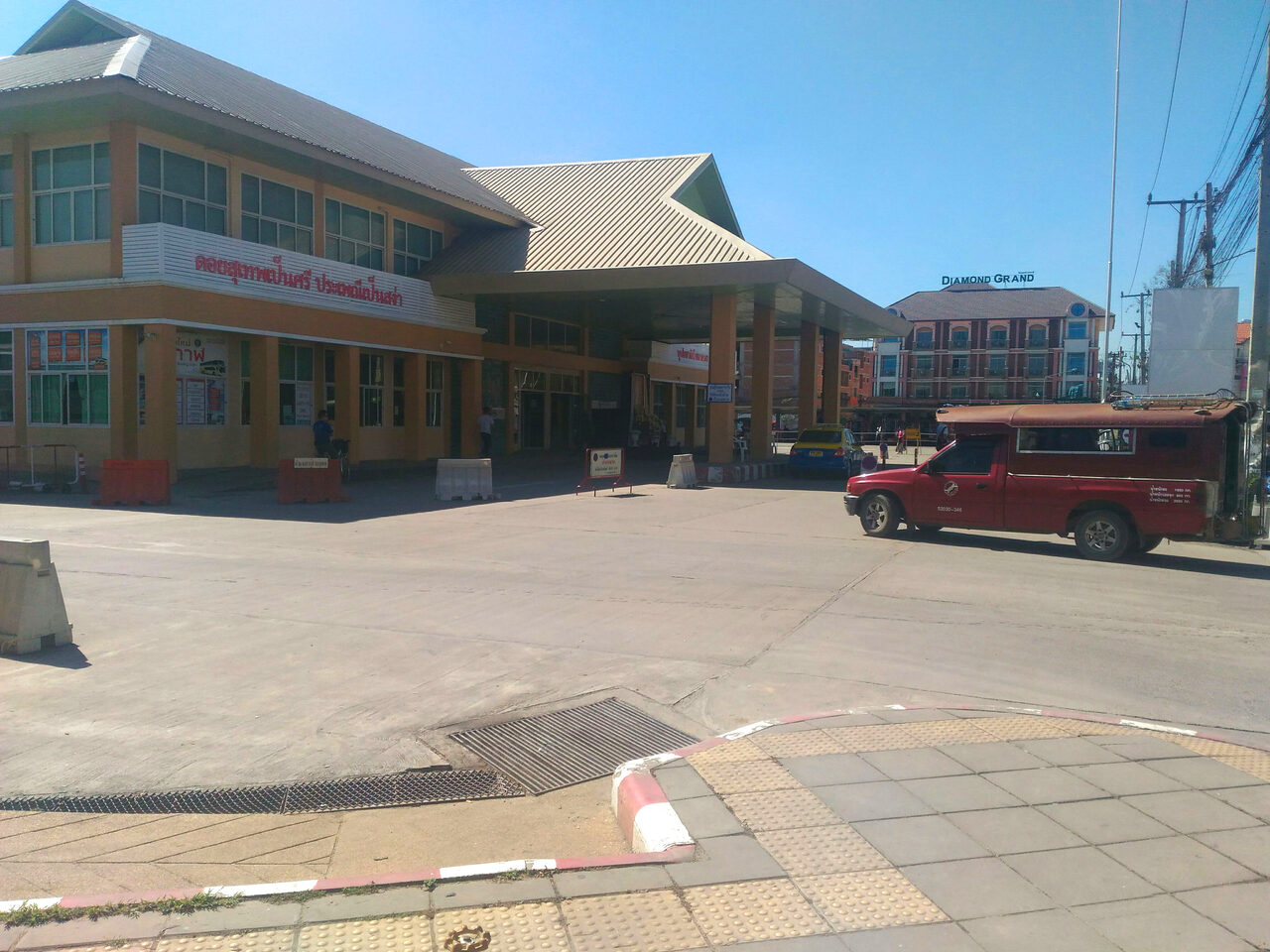 Exterior of the new terminal building at Arcade Bus Station Chiang Mai with a red songthaew waiting outside, the departure hall for budget travel guide routes north to Chiang Rai
