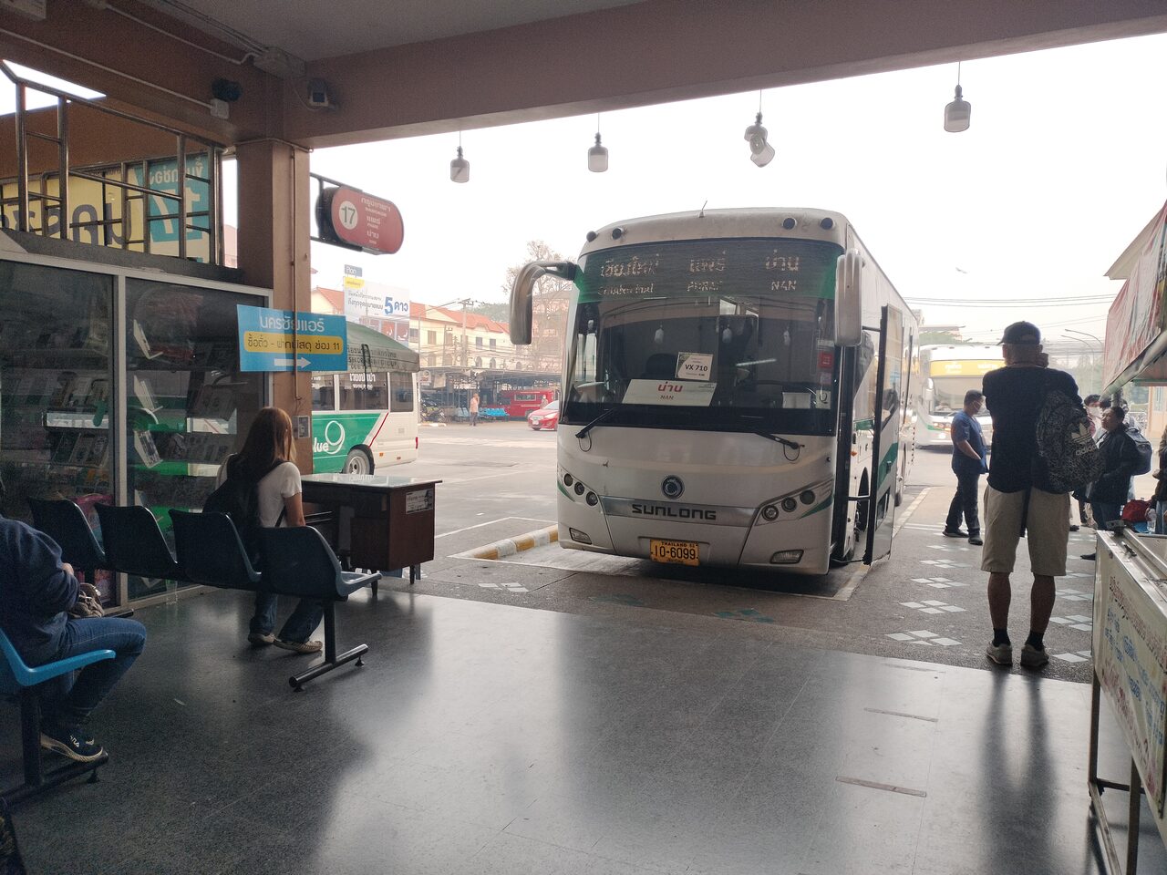 Green Bus coach loading at a numbered bay inside Chiang Mai Arcade Bus Terminal 3, the departure point for Thailand budget travel services to Chiang Rai