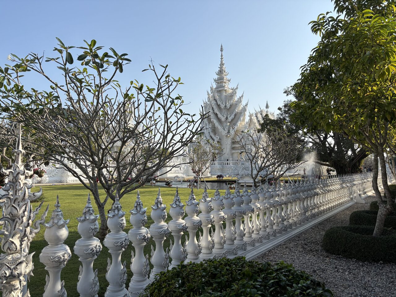 Wat Rong Khun, the White Temple at Chiang Rai, seen across its lawns, where foreign visitors pay a 200-baht entrance fee in 2026 against free entry for Thai nationals